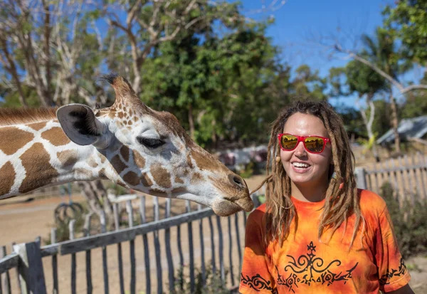 Mädchen füttert Giraffe im Zoo — Stockfoto