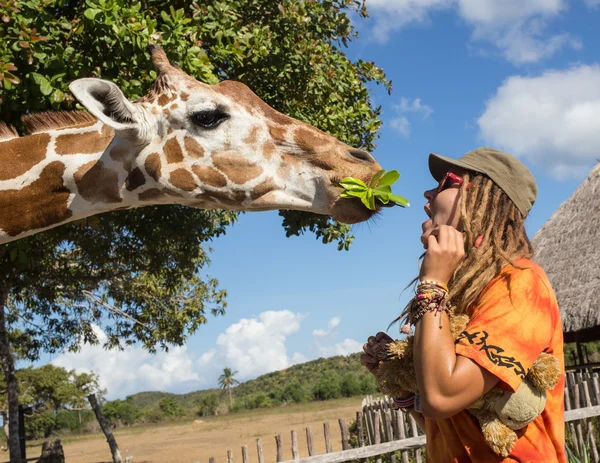 Mädchen füttert Giraffe im Zoo — Stockfoto