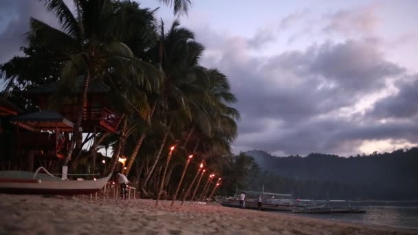 夕暮れ時のカップルの熱帯のビーチの赤のトーンの画像 — ストック動画