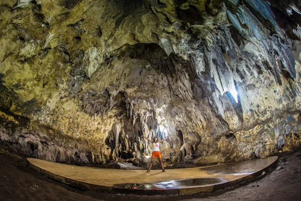 Jovem com mochila explorando caverna — Fotografia de Stock