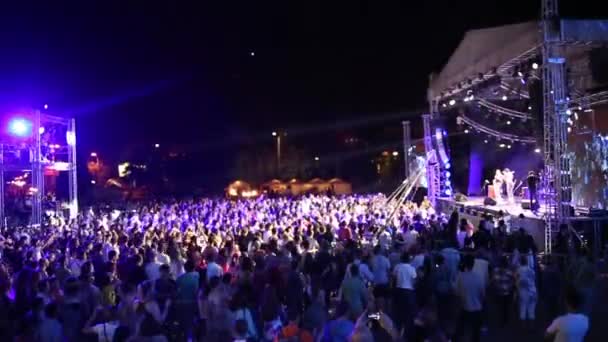 카자흐스탄, 알마티, 도시 광장-2015 년 7 월 6 일: 큰 자선 콘서트 성령의 Tengri 2015 년, 밝은 무대 조명의 앞에 연주회 군중의 실루엣 — 비디오