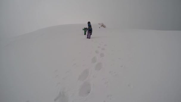 Esquiadores caminando cuesta arriba — Vídeos de Stock