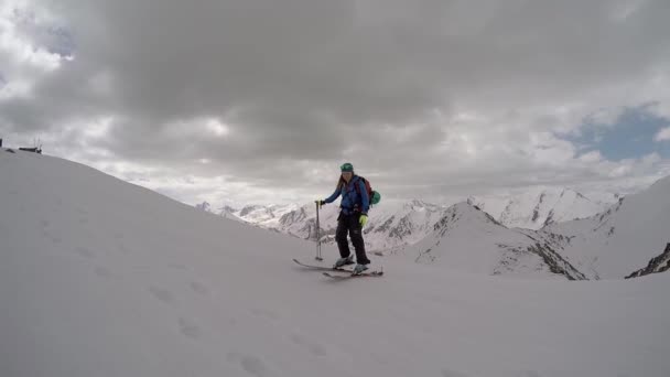 Bergbeklimmer bereikt de top van een besneeuwde ridge en spreekt zijn vreugde — Stockvideo