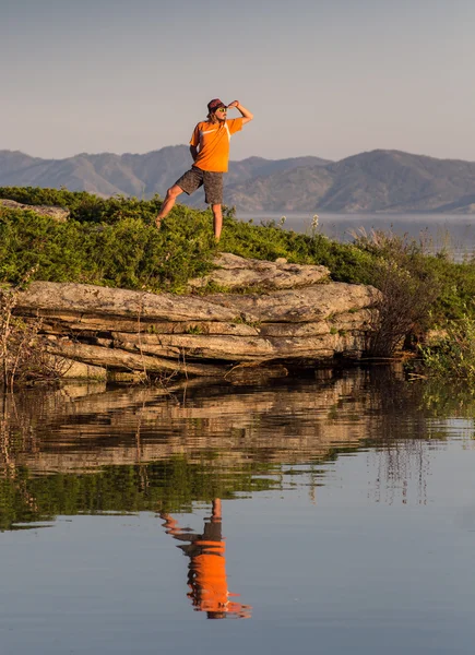 Uomo sedersi e scattare foto in macchina fotografica al lago con cielo al tramonto . — Foto Stock