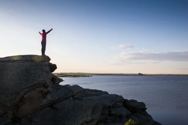 Mujer joven sentada en la roca y disfrutando de una hermosa vista — Foto de Stock