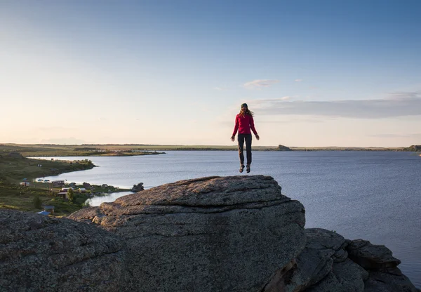 Giovane donna seduta sulla roccia e godendo di una bella vista — Foto Stock