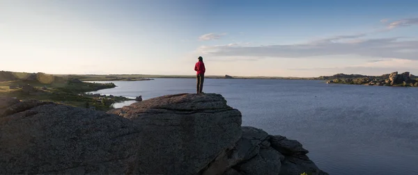 Young woman sitting on rock and enjoying beautiful view — Stock Photo, Image