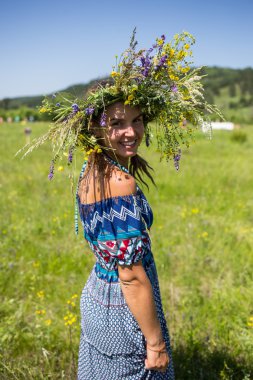 Papatya alanındaki kıvırcık kırmızı saçlı güzel genç kız