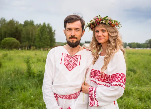 Casal em russo vestido tradicional no prado — Fotografia de Stock