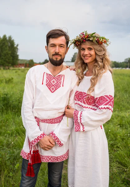 Casal em russo vestido tradicional no prado — Fotografia de Stock