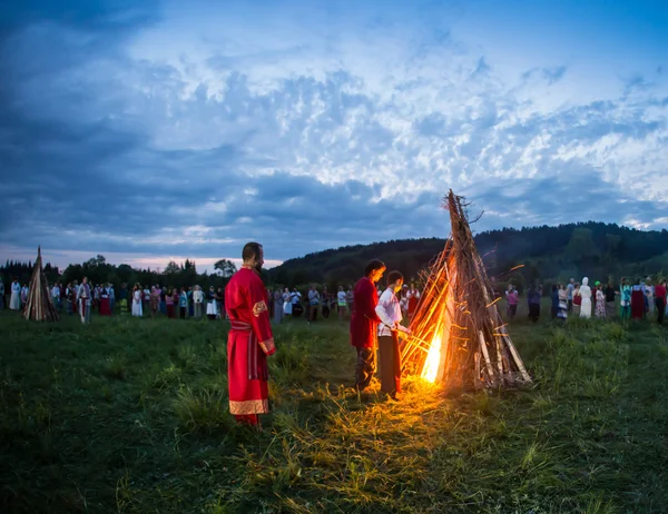 Människor firar den semester och ryska dans i en cirkel runt heliga elden — Stockfoto