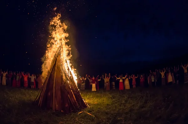 As pessoas celebram o feriado e a dança russa em um círculo em torno do fogo sagrado — Fotografia de Stock