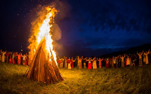 La gente celebra la festa e la danza russa in cerchio attorno al fuoco sacro Immagine Stock