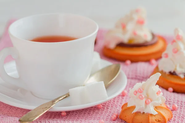 Чашка чая с чайной ложкой и печеньками — стоковое фото