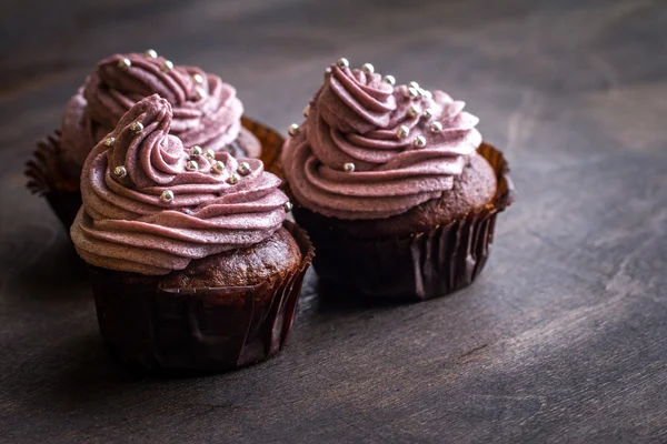 Choklad cupcakes dekorerade med bär grädde Stockbild