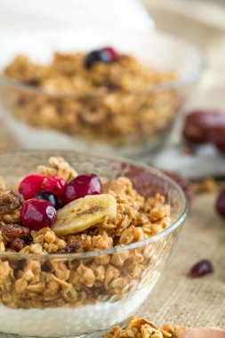 İki kahvaltı kase kuru müsli, süzme peynir ve Grey tahta kaşıkla kırmızı meyveler masa örtüsü tuval