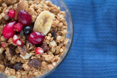 kahvaltı kase kuru müsli ve mavi mutfak havlu üzerinde kırmızı meyveler