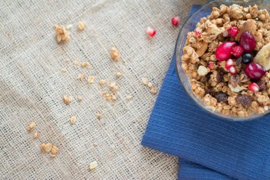 Kahvaltı kase müsli ve mavi mutfak havlu kaşık ile kırmızı meyveler