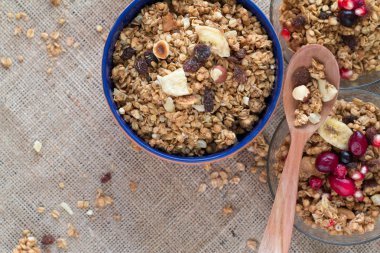 Üç müsli kahvaltı seramik ve cam kase kırmızı meyveler ve tahta kaşık ile