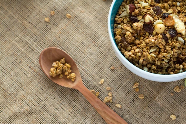 Granola kahvaltı tuval masa örtüsü üzerinde tahta kaşıkla yuvarlak mavi seramik kase