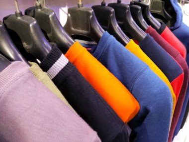 Çok renkli bir elbise olan Sherwani Kurta, bir mağazada satılık olarak asılı duruyor.