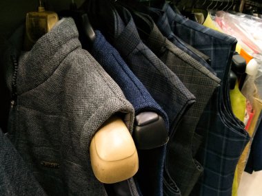 Çok renkli bir elbise olan Sherwani Kurta, bir mağazada satılık olarak asılı duruyor.