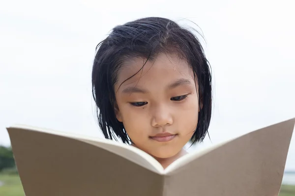 Linda chica leyendo un libro . — Foto de Stock