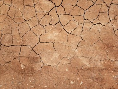 Zemin, kuraklık ve ölüm kavramına sahip arka plan veya grafik tasarımı için üst görünümde çatlaklar var..