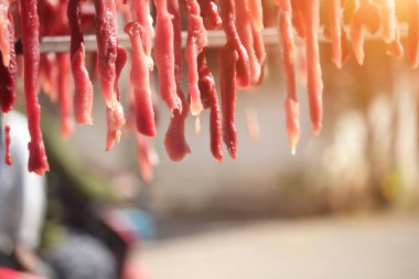 Korkulukta dilimlenmiş domuz ve biftek. Satılık ya da tüketim için güneşe maruz kalarak uzun süre yiyecek depolanacak..