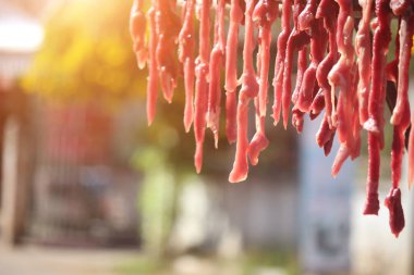 Korkulukta dilimlenmiş domuz ve biftek. Satılık ya da tüketim için güneşe maruz kalarak uzun süre yiyecek depolanacak..