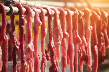 Korkulukta dilimlenmiş domuz ve biftek. Satılık ya da tüketim için güneşe maruz kalarak uzun süre yiyecek depolanacak..