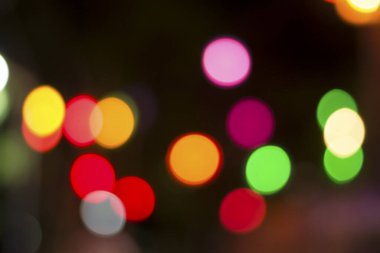 Gecenin karanlığında bulanık renkli bokeh ışıkları. Grafik tasarımı için arka planlar, Noel tatilleri, Yeni Yıl festivalleri veya kutlamalar.