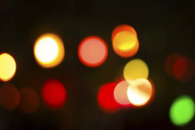 Gecenin karanlığında bulanık renkli bokeh ışıkları. Grafik tasarımı için arka planlar, Noel tatilleri, Yeni Yıl festivalleri veya kutlamalar.