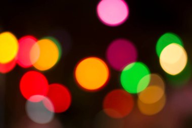 Gecenin karanlığında bulanık renkli bokeh ışıkları. Grafik tasarımı için arka planlar, Noel tatilleri, Yeni Yıl festivalleri veya kutlamalar.