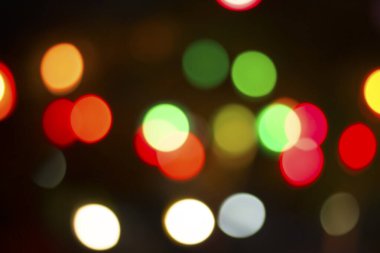 Gecenin karanlığında bulanık renkli bokeh ışıkları. Grafik tasarımı için arka planlar, Noel tatilleri, Yeni Yıl festivalleri veya kutlamalar.