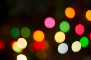 Gecenin karanlığında bulanık renkli bokeh ışıkları. Grafik tasarımı için arka planlar, Noel tatilleri, Yeni Yıl festivalleri veya kutlamalar.