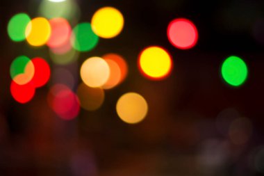 Gecenin karanlığında bulanık renkli bokeh ışıkları. Grafik tasarımı için arka planlar, Noel tatilleri, Yeni Yıl festivalleri veya kutlamalar.