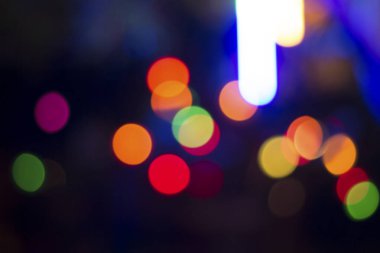 Gecenin karanlığında bulanık renkli bokeh ışıkları. Grafik tasarımı için arka planlar, Noel tatilleri, Yeni Yıl festivalleri veya kutlamalar.