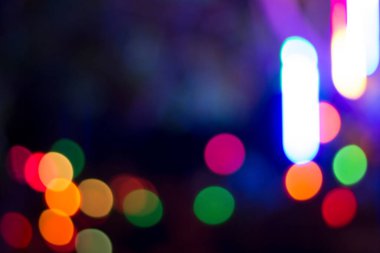 Gecenin karanlığında bulanık renkli bokeh ışıkları. Grafik tasarımı için arka planlar, Noel tatilleri, Yeni Yıl festivalleri veya kutlamalar.