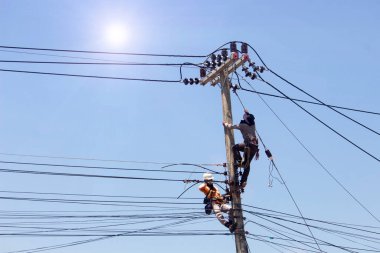 Elektrikçi elektrik direğine elektrik tesisatı kuruyor. Güvenlik ekipmanları ile yükseklerde çalışan mühendis. 