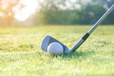 Golf sopaları ve golf topları yeşil çimlerde sabah güneşli güzel bir golf sahasında. İlk kısa devre için hazır. Dünyanın dört bir yanındaki insanların sağlık için yaptıkları sporlar..