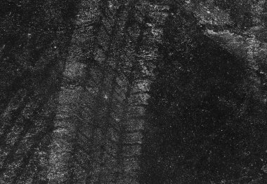 Close up black tire marks on cement floor. Abstract concrete texture in vintage style. Dark background for graphic design or wallpaper. Stains on the road surface caused by the wheels of the car.