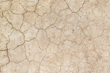 Zemin, kuraklık ve ölüm kavramına sahip arka plan veya grafik tasarımı için üst görünümde çatlaklar var..