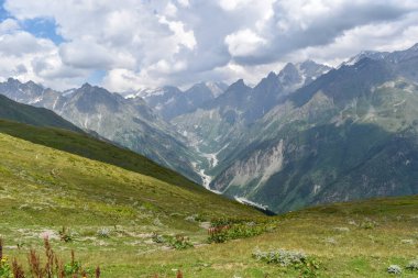 Svaneti bölgesinde yaz dağı manzarası, Gürcistan, Asya. Arka planda karlı dağlar, Kafkasya dağ sıraları. Yukarıdaki bulutlar. Gürcistan 'a seyahat
