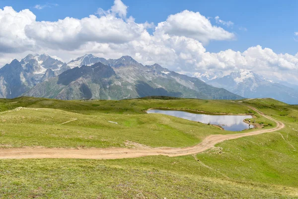 Turista útvonal Koruldi-tavak, Szvaneti régió, Grúzia, Ázsia. Kaukázus hegység. Népszerű túra Mestiából. Zöld alpesi táj hófödte hegyek a háttérben — Stock Fotó