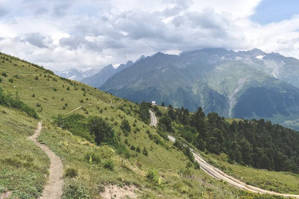 Nyári hegyvidéki táj egy túraútvonal Szvaneti régióban, Georgia, Ázsia. Snowcapapped hegyek a háttérben. Kék ég, felhőkkel felettünk. Grúzia úti célja — Stock Fotó