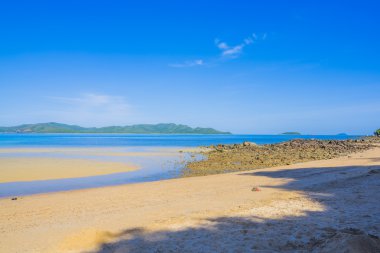 Sörfçü güzel plaj ve okyanus mavi gökyüzü ile
