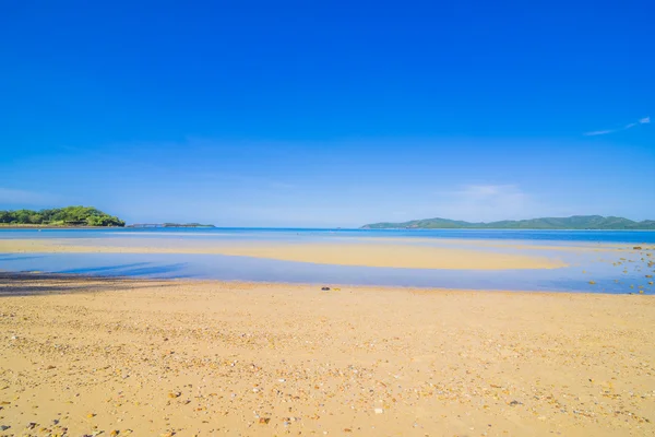 Серфер на пляже Претти и в океане с голубым небом — стоковое фото
