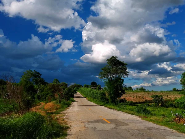 road under a blue sky with soft clouds.