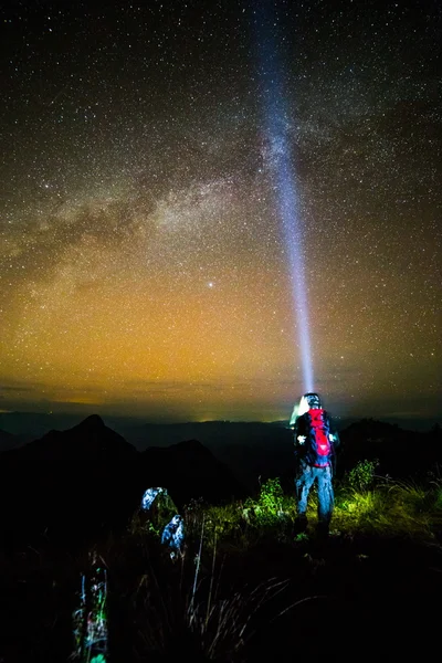 Young man Standing on Mountain with night sky — Stock Photo, Image